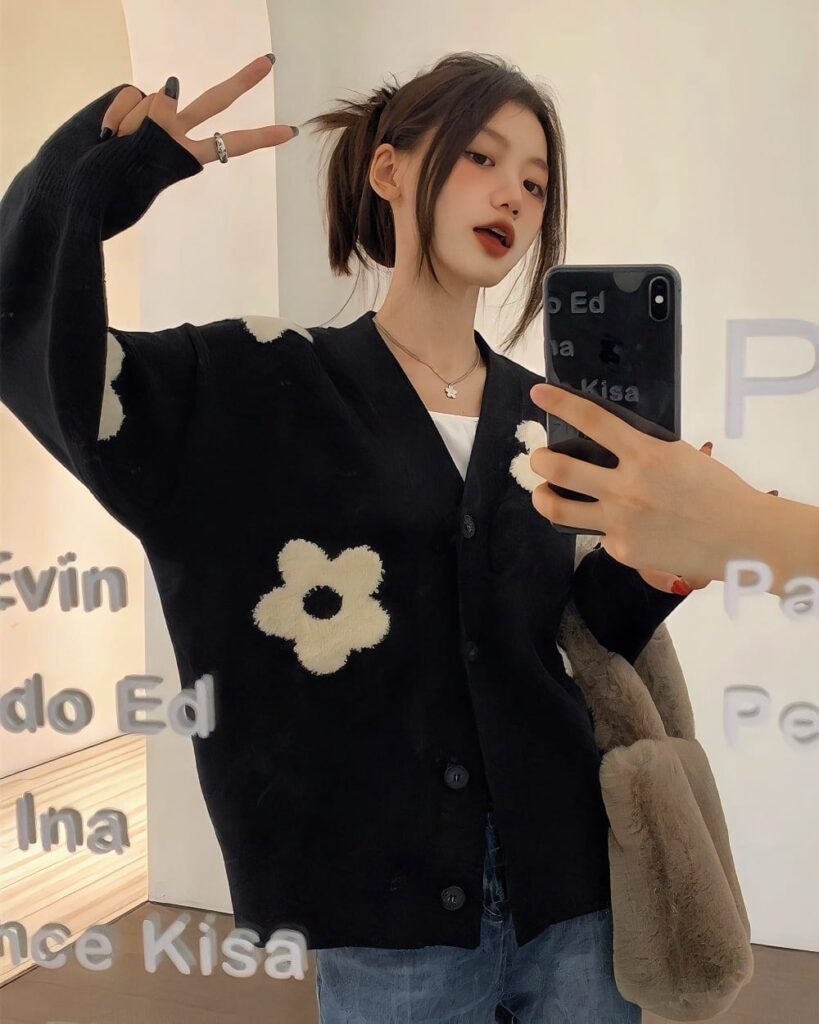 Close-up of a korean cardigan featuring a large, plush flower design.