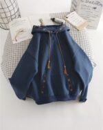 Dark blue ethno-chic hoodie with embroidered details and tassels.