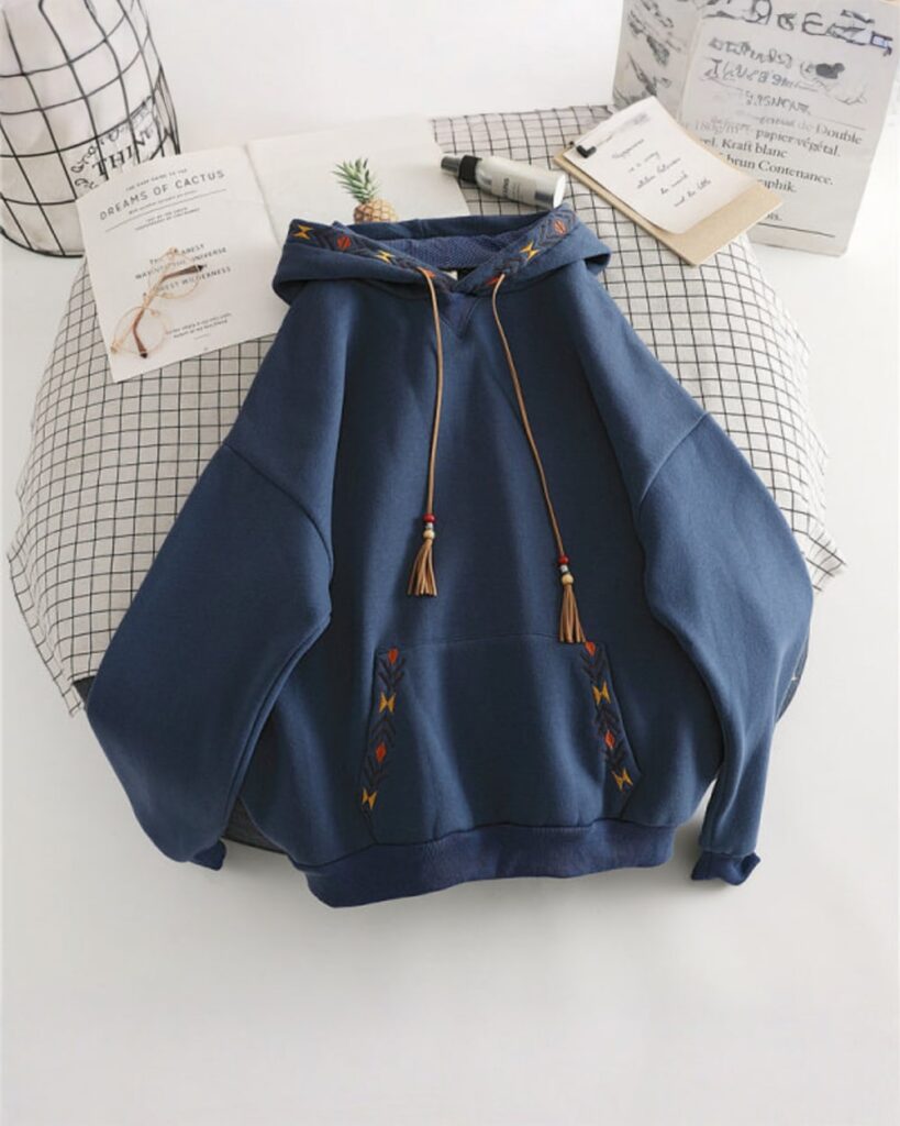 Dark blue ethno-chic hoodie with embroidered details and tassels.