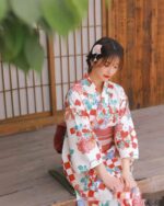 A woman wearing a retro checkered kimono with floral and geometric patterns in red, blue, and white.
