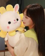 A white kawaii bunny plushie with yellow accents, held by a person.