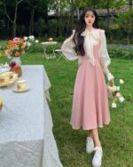 Long pink dress - vintage aesthetic dress, floral background, outdoor setting.