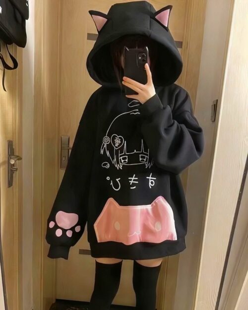 Black cat ear hoodie featuring paw prints and Japanese text. Cute core aesthetic apparel.