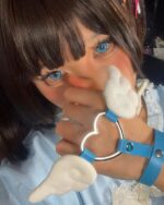 Close-up of a person wearing winged love bracelets and blue makeup.