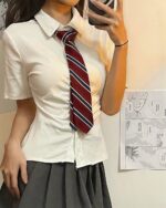 Close-up of a girl wearing a preppy aesthetic uniform set, featuring a white shirt and red and white tie.