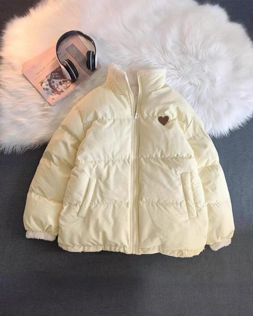 Cream-colored bear heart jacket displayed on a fluffy rug with a newspaper.