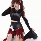 Black crop top and a punk plaid denim skirt with frayed edges are worn by a model.