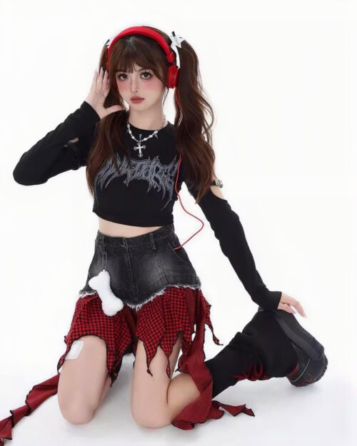 Black crop top and a punk plaid denim skirt with frayed edges are worn by a model.