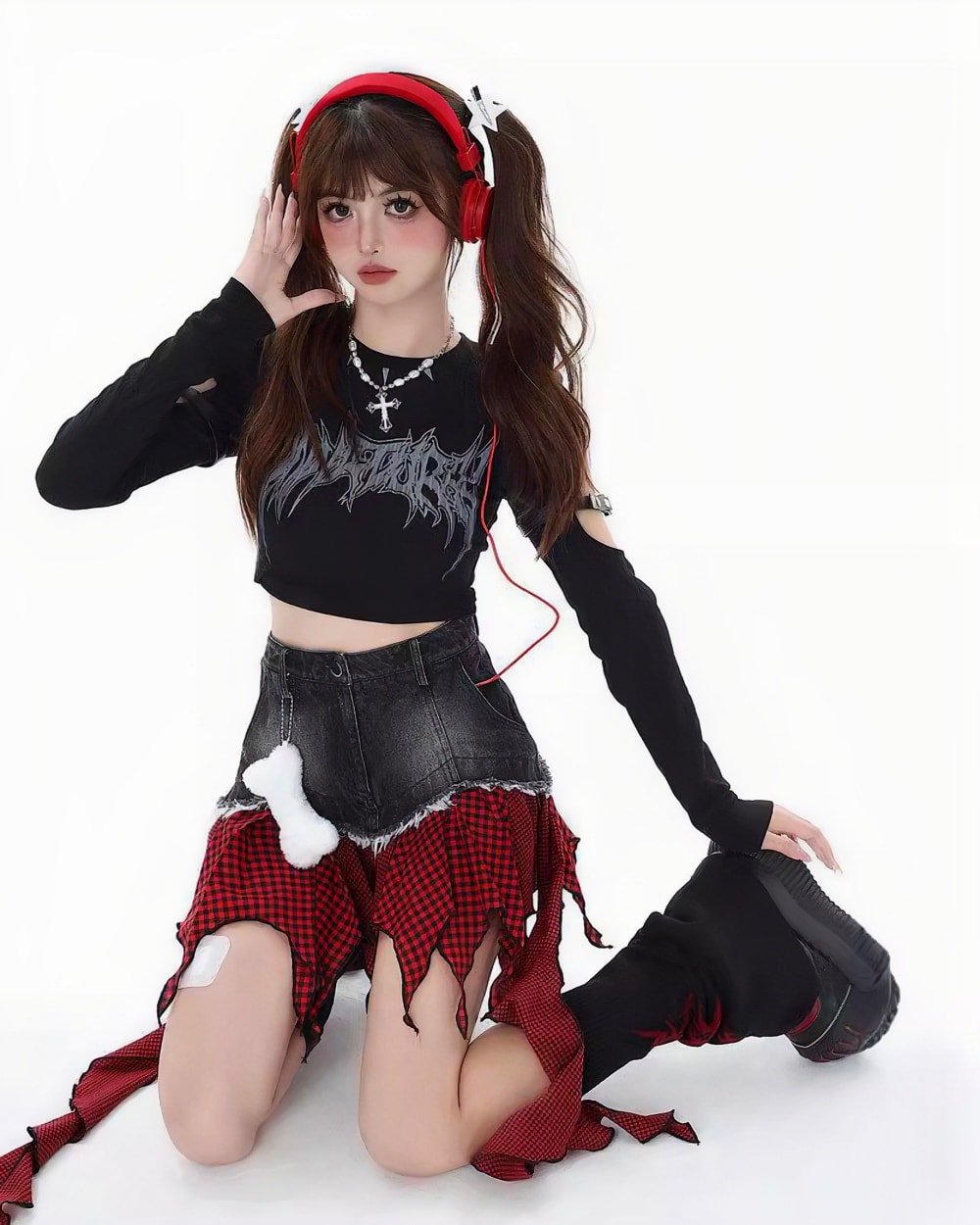 Black crop top and a punk plaid denim skirt with frayed edges are worn by a model.
