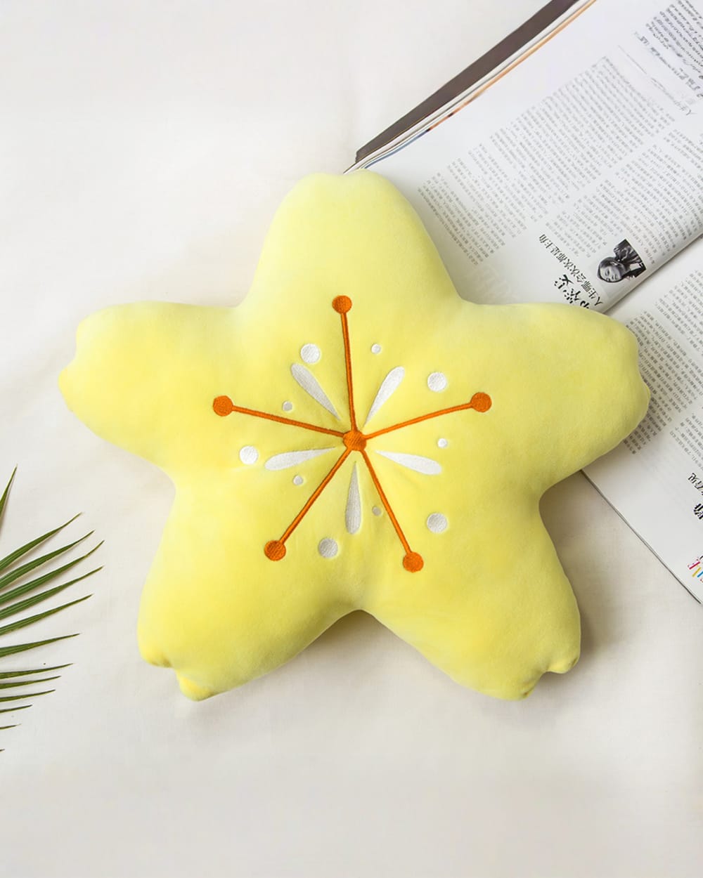 Close-up of a Sakura flower pillow, a star-shaped cushion with a white floral design.