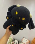 Close-up of a black kawaii space sheep plushie with yellow accents and soft fur texture.