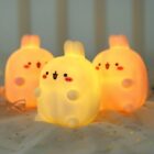 Three kawaii Molang bunny lamps illuminate a pink fabric background.