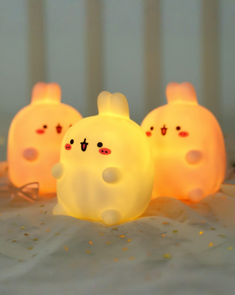 Three kawaii Molang bunny lamps illuminate a pink fabric background.