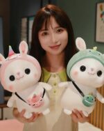 Two kawaii bunny plushies, one pink and one green, with hats. Aesthetic rabbit toy.