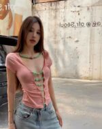 A pink korean off-shoulder top with a detailed neckline and ribbed texture.