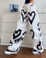White y2k aesthetic pants with a graffiti heart and splatter print design, high waist, loose fit.