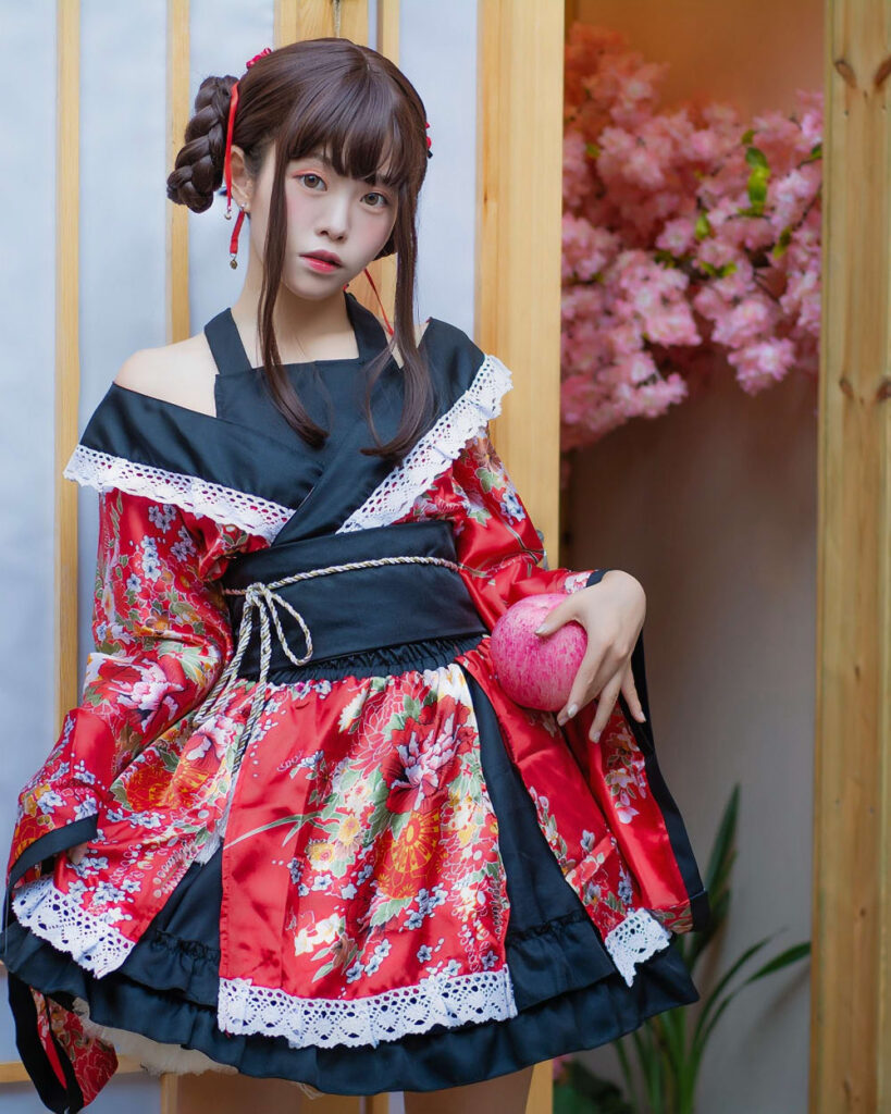 Red and gold harajuku aesthetic kimono worn by a model, featuring intricate floral patterns and layered ruffles.