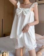 White soft girl pajamas with ruffled details and a delicate, textured fabric. Comfortable sleepwear.