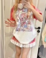 Pink kawaii t-shirt with anime character print, layered with a ruffled skirt.