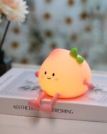 Small peach night lamp, kawaii decorative LED lamp, emits a warm glow.