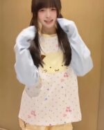 Person wearing a blue harajuku cat sweatshirt with a cat print and stars.