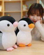 Two Pip and Family penguin plushies displayed on a wooden surface.