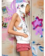 White sleeveless punk hoodie featuring a grunge graphic design, worn by a person.