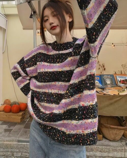 Purple and grey striped y2k sweater worn by a person.
