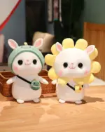 Two kawaii bunny plushies, one wearing a green hat and holding a toy, and another with yellow flower ears.