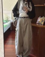 Model wearing a dog doodle t-shirt with baggy pants and a black sweater.