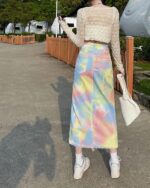 Colorful y2k denim skirt with a tie-dye pattern and frayed hem.