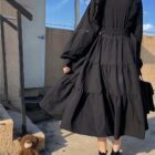Close-up of a black gothic lolita dress with puff sleeves and layered skirt.