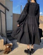 Close-up of a black gothic lolita dress with puff sleeves and layered skirt.