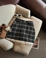 Plaid mini skirt with a preppy aesthetic, featuring a plaid pattern and ruffled hem.