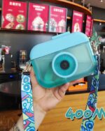 Kawaii camera bottle with a blue design and colorful strap, portable drinking bottle.