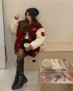 Red and white Korean aesthetic jacket worn by a woman, featuring contrasting sleeves and a casual outfit.