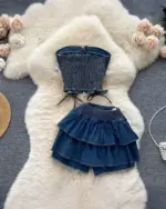 Two-piece coquette denim set featuring a crop top and ruffled denim skirt.