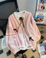 Light pink kawaii bow sweater with checkered details and buttons.