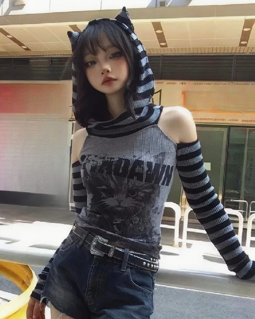 Close-up of a striped off-shoulder hoodie with a grunge aesthetic, featuring black and grey stripes and a graphic print.