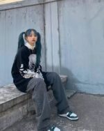 Black animecore sweater featuring a graphic print, worn by a person.