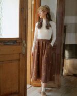 Brown retro aesthetic skirt with embroidered floral details, worn by a woman.