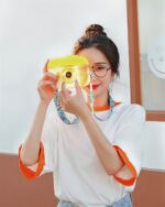 A person holding a kawaii camera bottle, a portable drinking bottle with a camera lens.