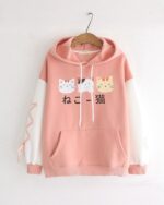 Pink neko pullover hoodie featuring three cat illustrations and Japanese text. Cute casual wear.