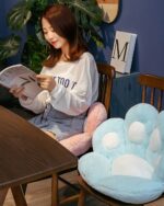 Kawaii neko pillow, a plush, blue cat-shaped cushion on a table.