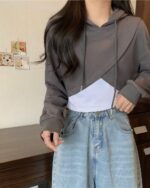 Irregular hooded top - Korean aesthetic hoodie showcasing layered design with denim pants.