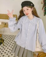 Light blue vintage aesthetic shirt with ruffled collar and buttons.