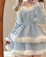 Close-up of a blue winter aesthetic dress with white faux fur trim and bows.