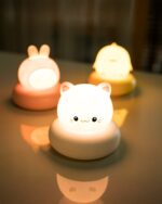 Several kawaii night lights, including a bunny and chick, on a table with warm light.