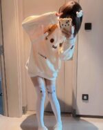 Model wearing a white kaomoji bear hoodie and thigh-high socks.
