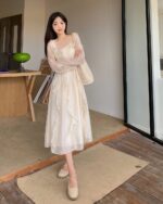 Woman wearing a French Style Long Sleeve Dress, a coquette aesthetic dress, in an outdoor setting.